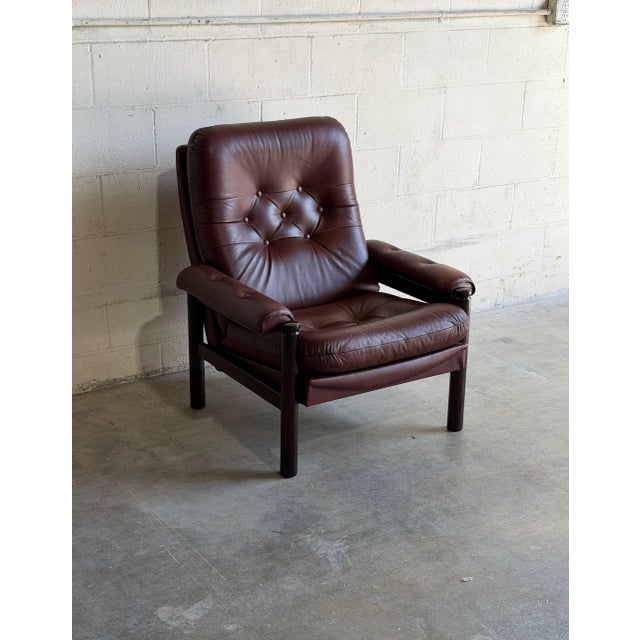 Beautiful vintage Danish lounge chair upholstered in rich brown leather with a solid wood frame. This elegant Scandinavian...