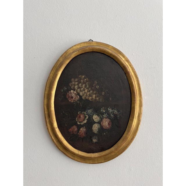 Oil on canvas still life from the 18th century. Italy. This dark-ground painting highlights a cascade of white grapes at...