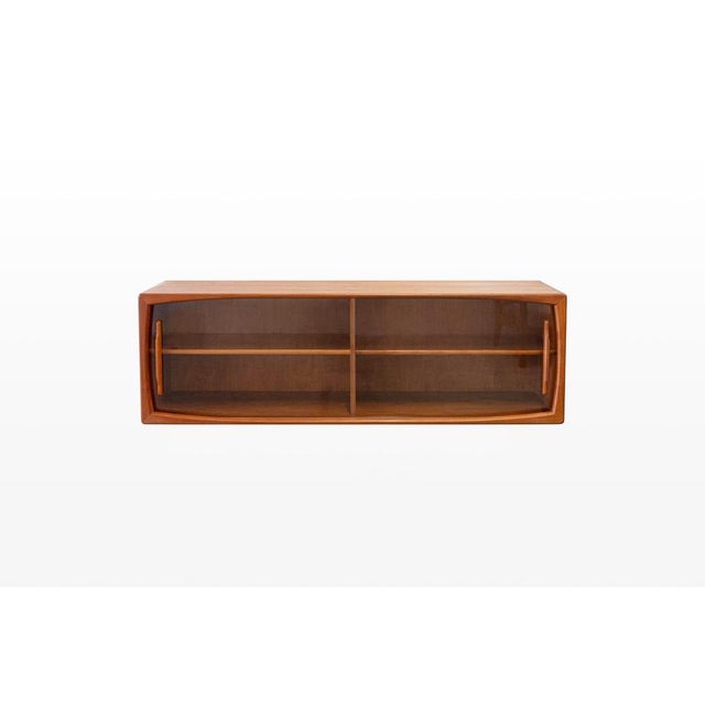 Floating display cabinet in teak. This sideboard has two glass doors with teak handles. The cabinet is easy to install on...