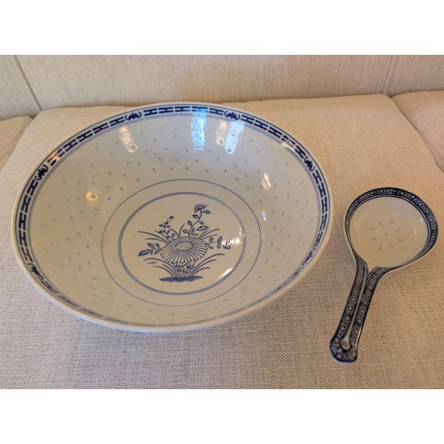 A large, 10-inch, serving bowl and spoon in the traditional blue and white rice eye pattern. Both bowl and spoon are in...