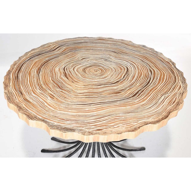 21st century, molded stone top emulating tree round, wrought and hammered black painted iron splayed base, unsigned,...