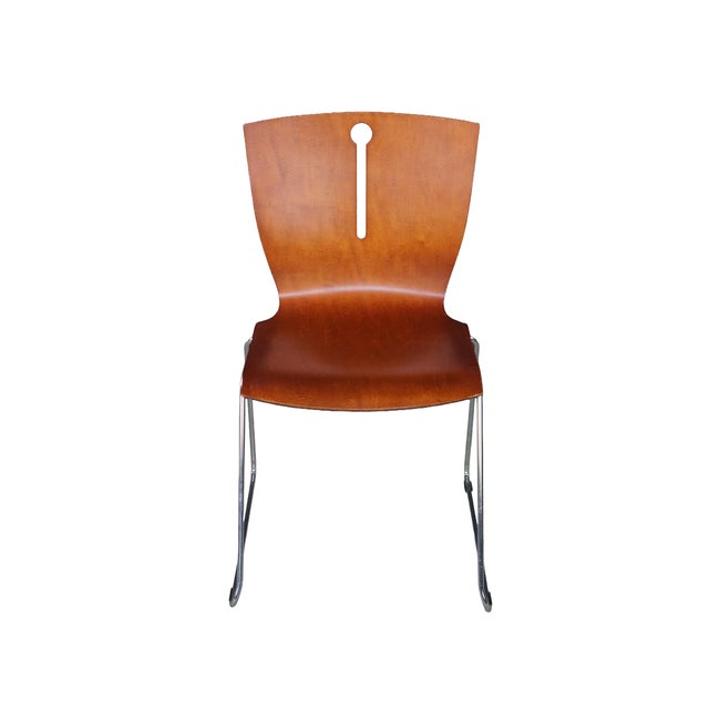 Set of four mid-century modern stacking bent plywood dining chairs showcasing a sleek, minimalist aesthetic defined by...