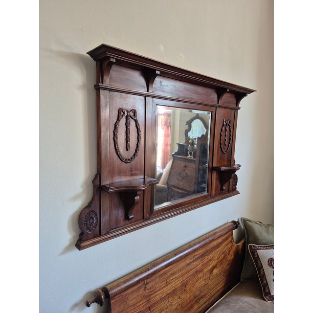 This piece is a large, wall-mounted antique which likely originated as a mantle or sideboard top/buffet mirror crafted...