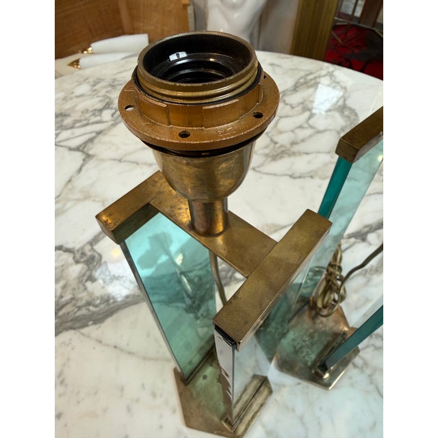 Elegant pair of modernist table lamps attributed to Fontana Arte, featuring sculptural brass frames combined with striking...