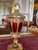 This ornate pedestal compote with a lid was purchased in Germany in the mid 1960’s. It features a deep ruby color with...