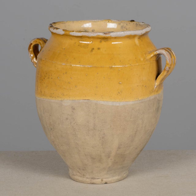 An earthenware confit pot from the Southwest of France with traditional yellow glaze. Minor losses to glaze. These...