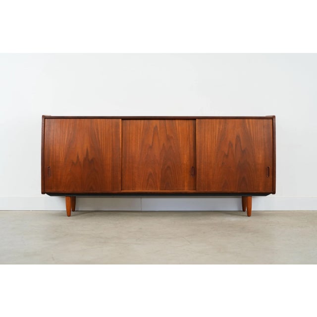 The sideboard was made in the 1970s, Danish production. The structure is covered with teak veneer. The legs are made of...