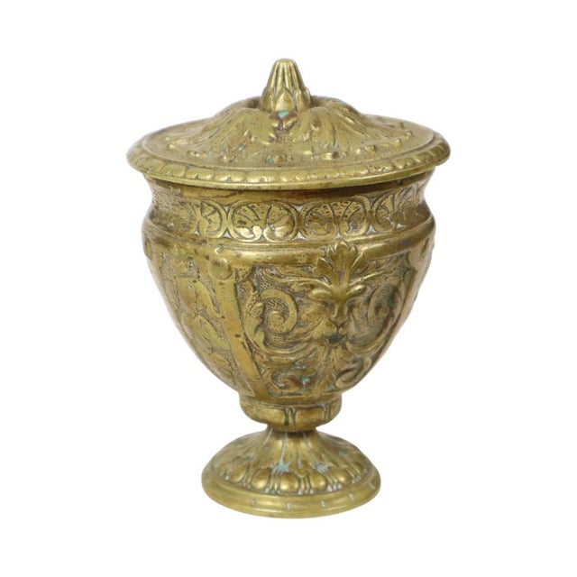 Old and heavy brass cup with lid, decorated at the top with a rosette and along the sides with acanthus and mythical...