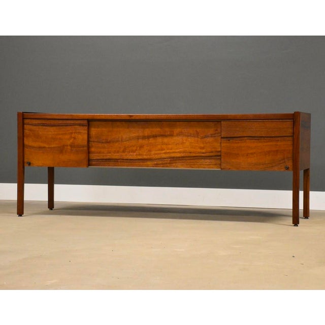 A mid century modern rare form paldao wood long sideboard credenza designed by Jens Risom with two sliding doors on top...