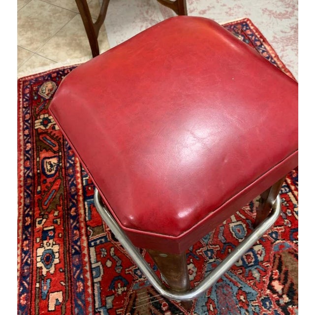 Vintage bar stool by Moderne Seating Co., showcasing a classic mid-century modern design with a vibrant red upholstered...