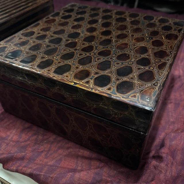 A supremely elegant black lacquer box with lid, decorated with delicate gold lines to create an organic honeycomb pattern....