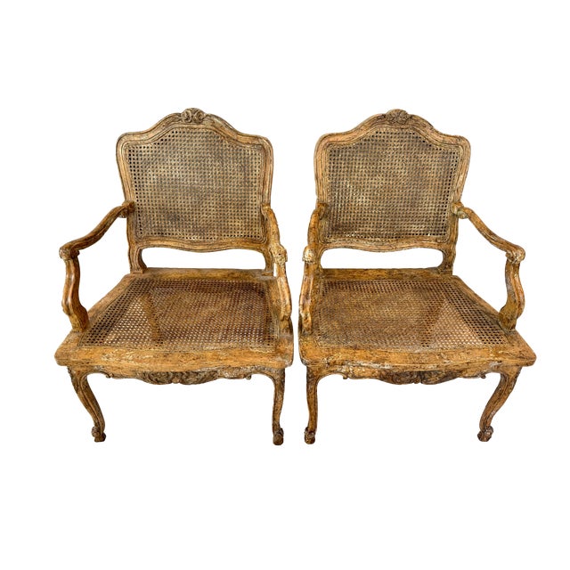A fabulous pair of Louis XV caned armchairs with elegantly carved wood frames and an amazing finish and patina. The...
