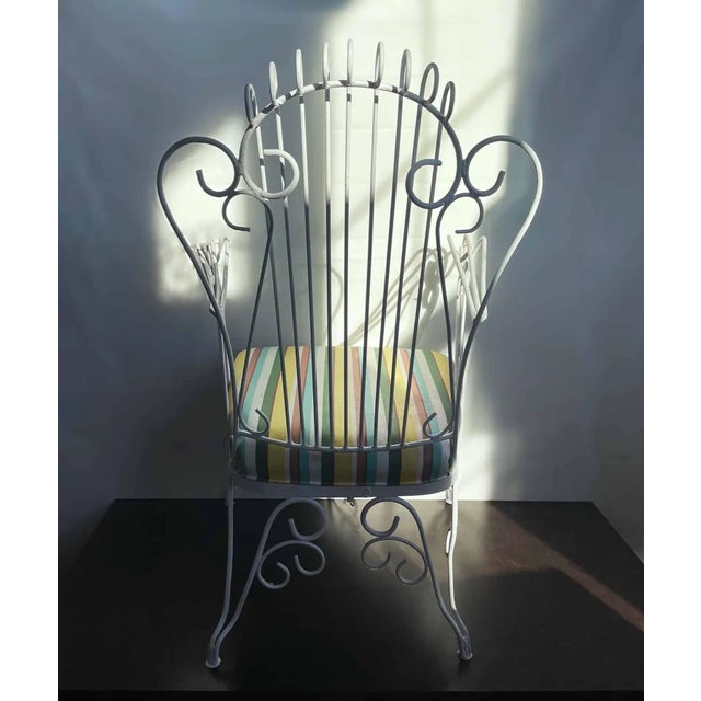 Pair of antique French white painted wrought iron armchairs. Custom yellow, green and blue striped cushions. Please...
