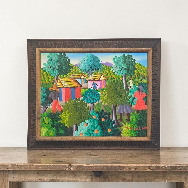 Signed by W. Coulano, this Haitian folk art painting depicts a tropical village landscape rendered in the vibrant visual...