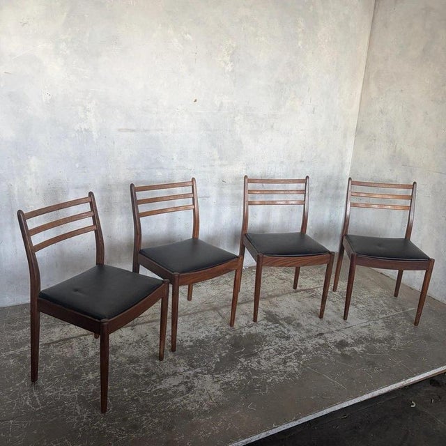 A stylish set of four original g plan dining chairs from the 1960s, featuring elegant teak ladder-back frames and...