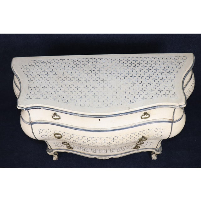 A wonderfully decorative pair of Italian Rococo Louis XV-style bombé commodes, beautifully finished in a soft crème-...