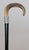 A superb antique English walking stick with an ebonized wood shaft, antler horn handle, and sterling silver collar. No...