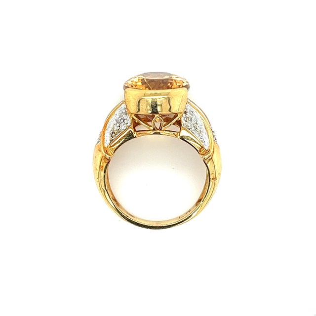 Vintage semi precious gemstone ring boasting an oval cut yellow topaz center stone, featuring round cut diamond side...