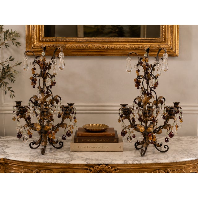 An extraordinary pair of circa 1940s Italian decorative candelabra crafted in dark patinated metal with remnants of a warm...