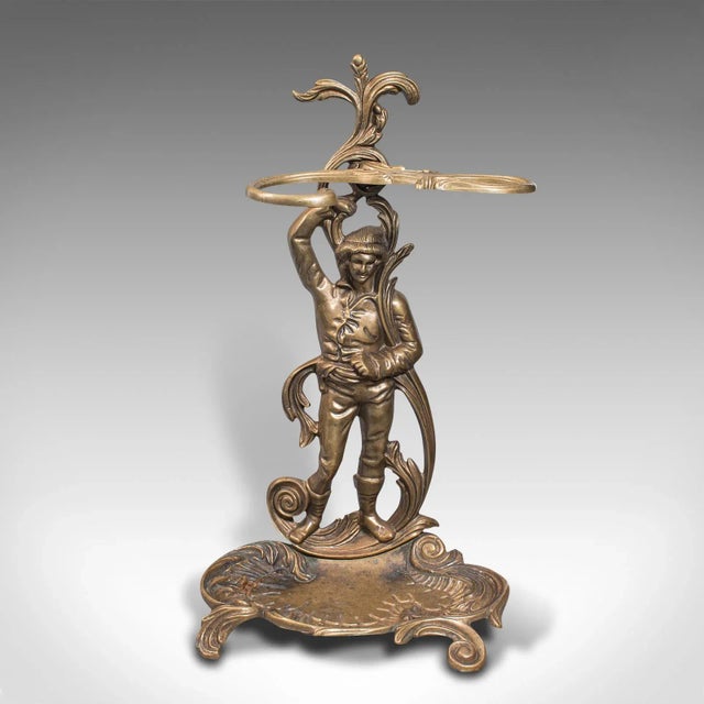 This is a vintage decorative stick stand. An Italian, pressed brass hall rack with figure, dating to the mid 20th century,...