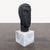 This sculpture features an abstract face design, crafted with a smooth finish and set on a solid white marble base. Its...