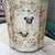 Whimsical vintage metal lamp with a cream background and a pair of charming pugs gracing the front. They are encircled...