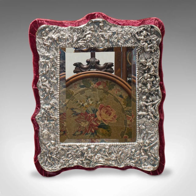 This is a vintage decorative mirror. An English, sterling silver and glass mirror, dating to the mid-20th century, circa...
