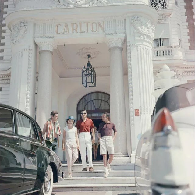 Staying At The Carlton 1958 Guests at the entrance to the Carlton Hotel, Cannes, France, 1958. Slim Aarons Slim Aarons was...