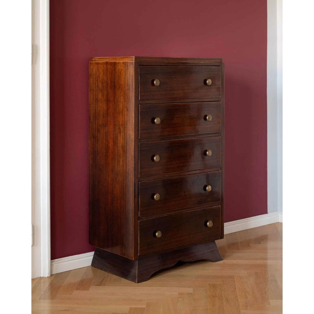 An elegant art-deco chest of drawers from France, made of noble rosewood. It is visually completed by original brass...