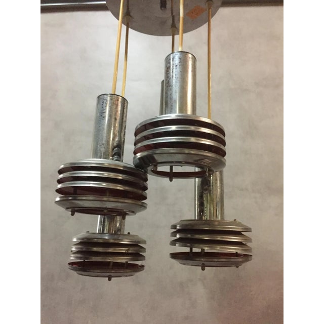 This 1970s vintage pendant light with five lights in chromed steel has an interior painted orange. European Plug (up to...