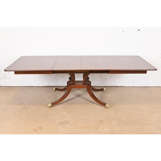 An exceptional Georgian or Regency style single pedestal extension dining table In the manner of Baker Furniture USA,...