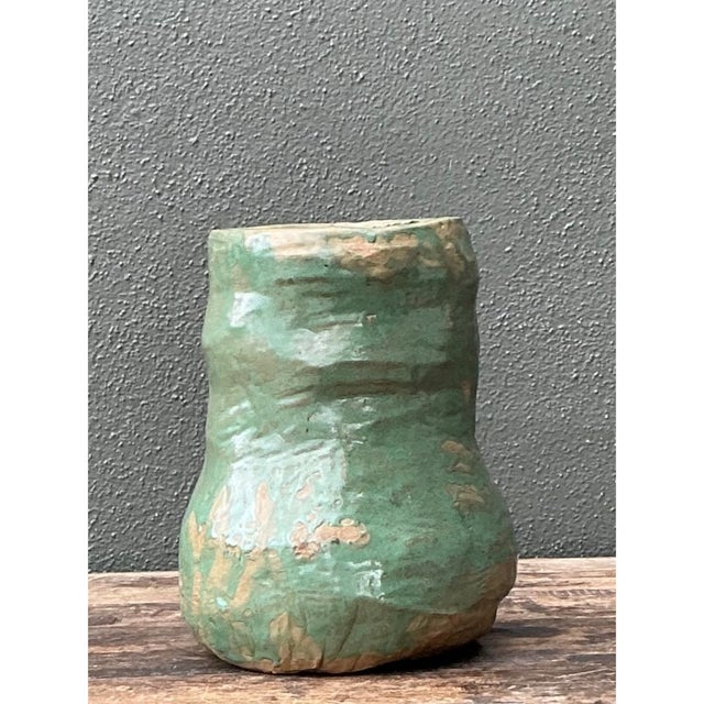 With its rounded silhouette and richly varied green glaze, this vintage ceramic vase brings an organic accent to a shelf,...