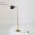Description Floor lamp with circular base and slim brass structure. The stem is adjustable in height and ends with a...