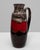 This 20th-century West German ceramic vase features the bold contrast and flowing glaze that define the iconic fat lava...