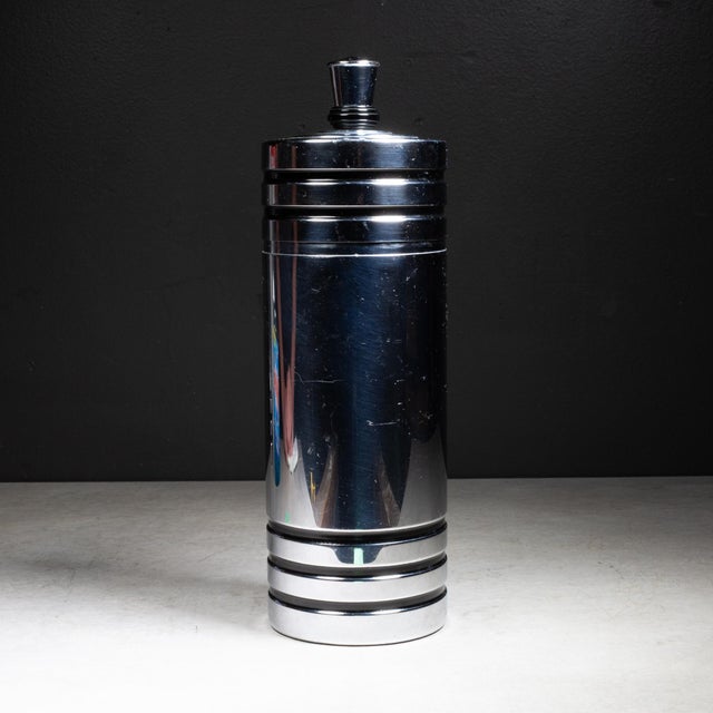 ABOUT Art Deco chromed copper cocktail shaker with black enamel bands and Bakelite collar. Cap lifts to reveal a...