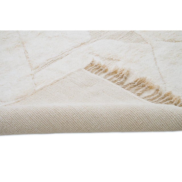 Elegant hand-knotted wool rug in soft Ivory hues, featuring a subtle abstract pattern. Its refined soft texture brings...