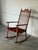 This rocking chair In style of Henning Kjærnulf features a high spindle backrest and distinctive contoured crest rail. Its...