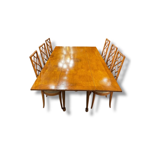A beautifully crafted vintage dining set featuring a warm wood finish and classic, timeless design. The rectangular table...