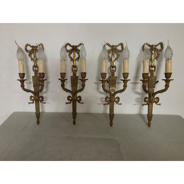 Set of 4 Louis XVI-style wall lamps Four refined gilded bronze wall lamps. Origin: French, first half of the 20th century....