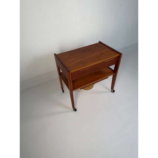 Original Danish teak side table from the 1960s, featuring a practical drawer and a distinctive woven storage basket...