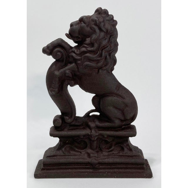 Large vintage cast iron doorstop featuring regal lion figure on podium. Very heavy with a great presence. Age wear.