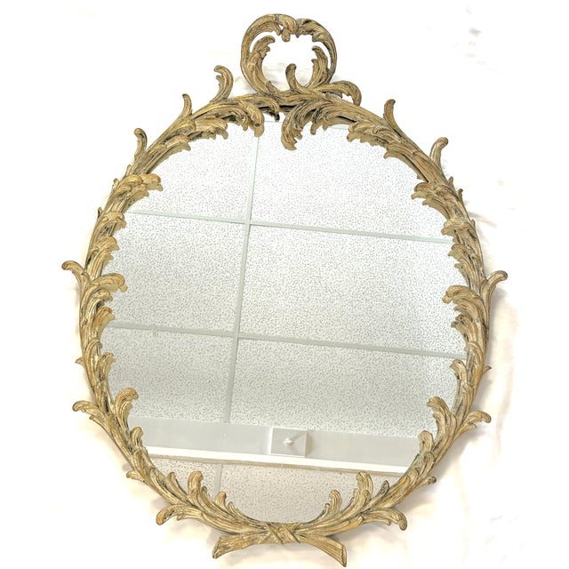 Great antique Hollywood Regency style wall mirror from the early 1900's. The large oval mirror is made of wood with...