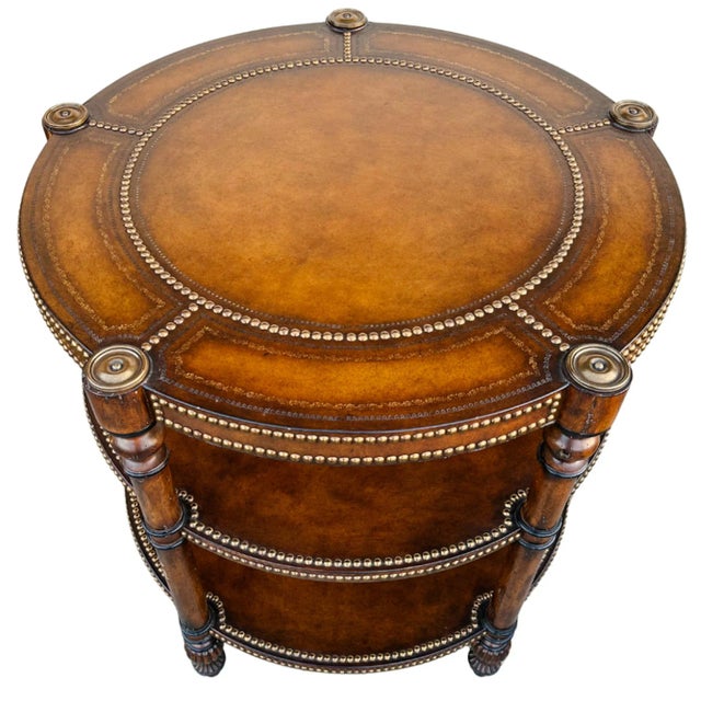 A very elegant three-tier round center table hand-made in a luxurious brown leather finish and dark wood construction...