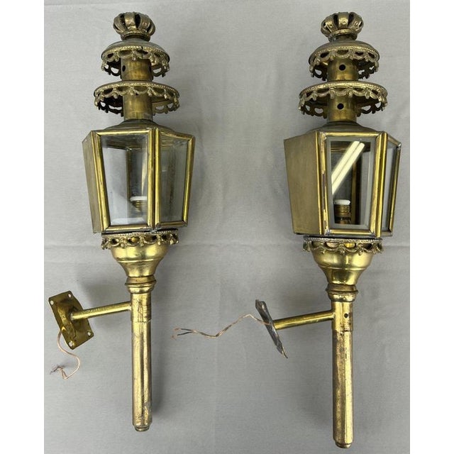 A decorative Antique pair of sconces featuring lantern-style glass-panelled bodies and ornate detailing. The matching pair...