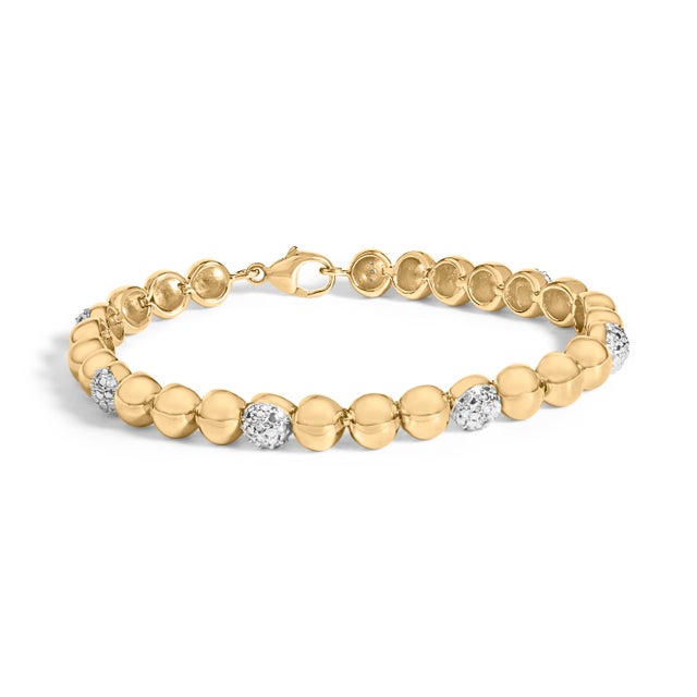 A luminous strand of rounded dome beads glides around the wrist like liquid sunlight, each high‑polish link reflecting a...