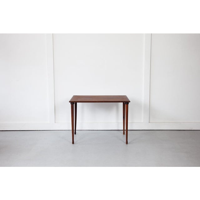 A beautiful rosewood side table, rectangular in shape, featuring wonderful grain detailing on its top and long, elegant legs.