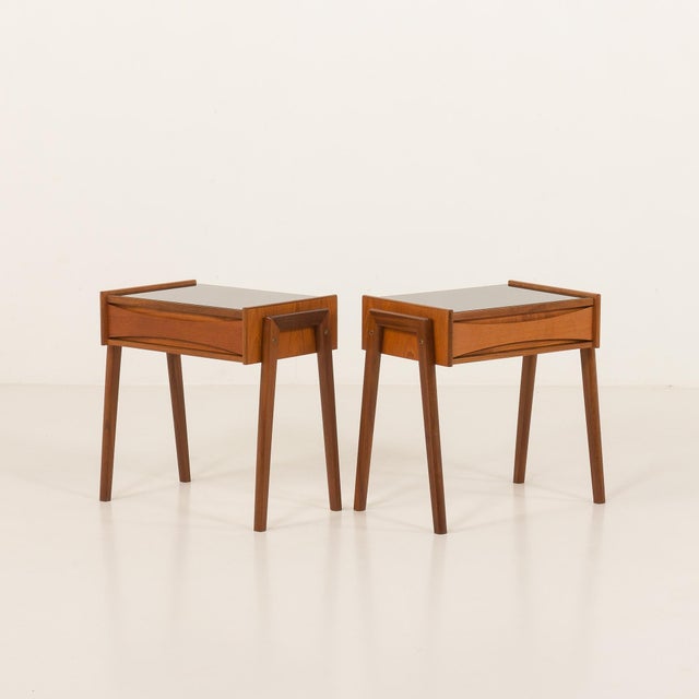 A pair of Arne Vodder style bedside tables or teak nightstands made in Denmark some time in the 1960s. They have been...