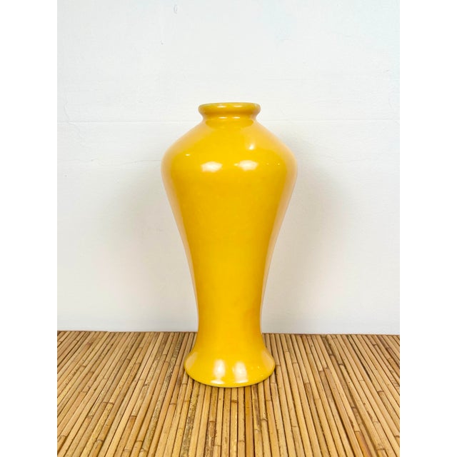 Vintage chinoiserie yellow ceramic vase. Elegant tall silhouette in rich marigold yellow glaze.