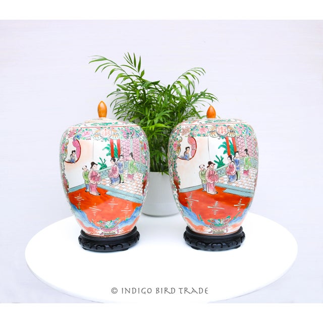 A pair of Chinese porcelain lidded jars decorated in the Famille Rose palette. This pair of Chinese porcelain jars with...