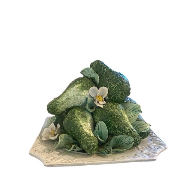 Wonderfully handcrafted greens with delicate white flowers where avocados sit piled on top of one another.